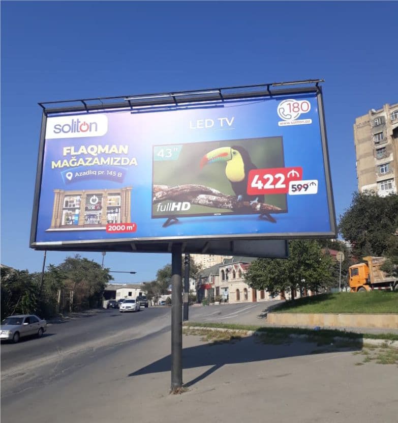 Yol kənarında metal dirək üzərində Soliton televizor reklamlı bilbord